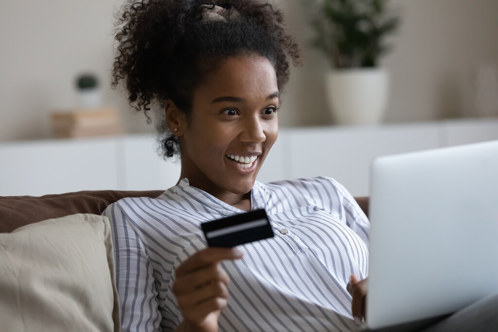 mulher fazendo compra pela internet usando seu cartão de crédito para negativado