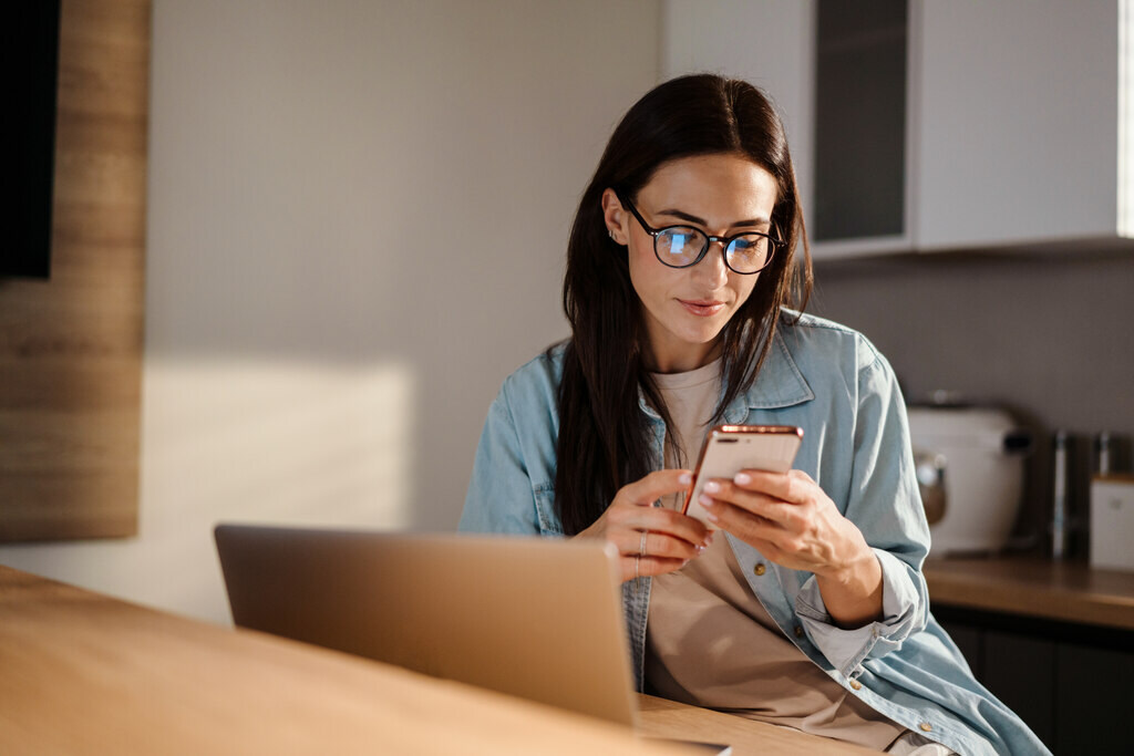 mulher pesquisando no celular como juntar 10 mil em 1 ano