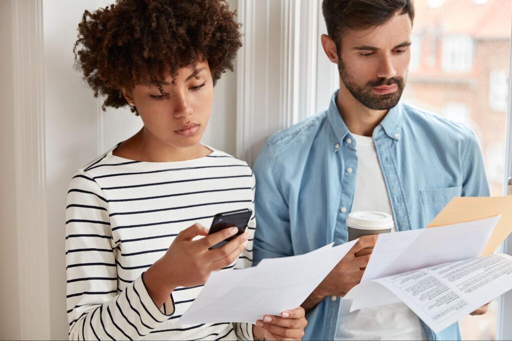 casal preocupado com as contas, pesquisando como negociar dívida