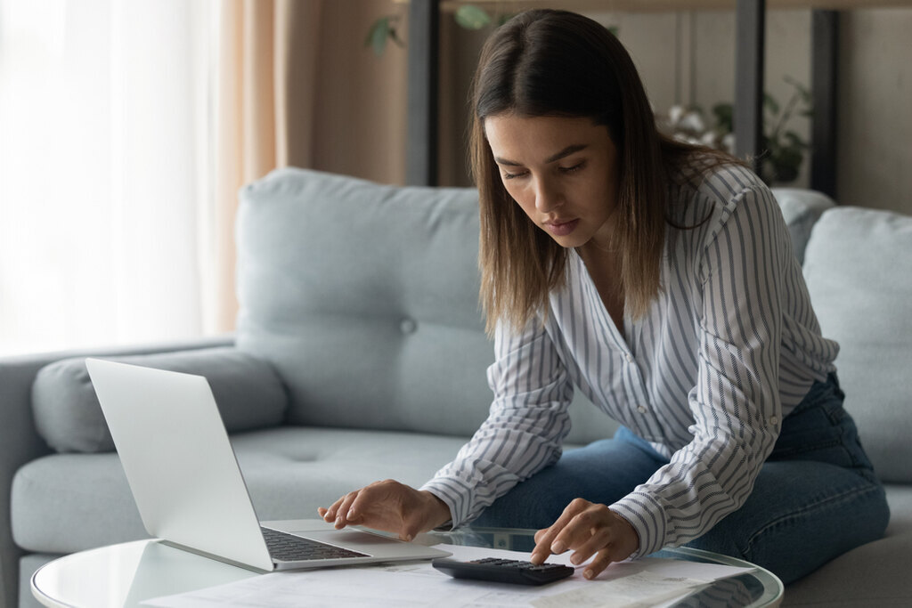 mulher pesquisando no notebook como sair das dívidas