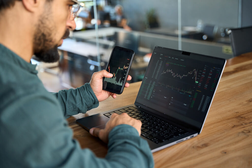 homem trabalhando como freelancer pelo computador e celular