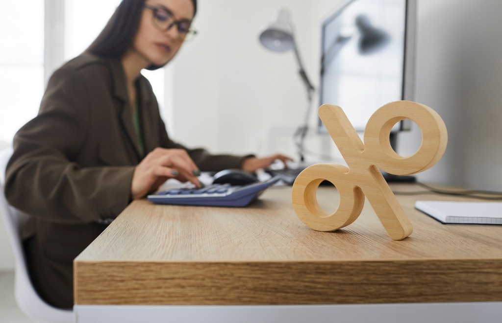 mulher em escritório calculando o custo efetivo total