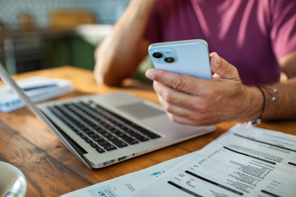 pessoa usando celular para fazer gestão financeira pessoal