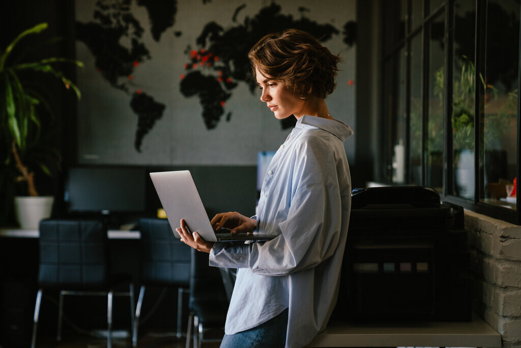 mulher pesquisando no notebook como investir em dólar