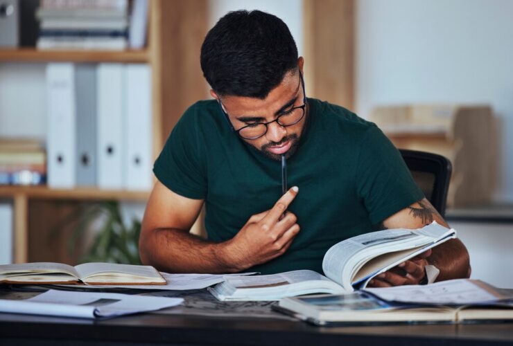 homem lendo livros sobre educação financeira