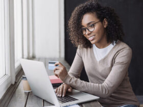 mulher usando o computador para escolher o melhor banco para antecipar FGTS