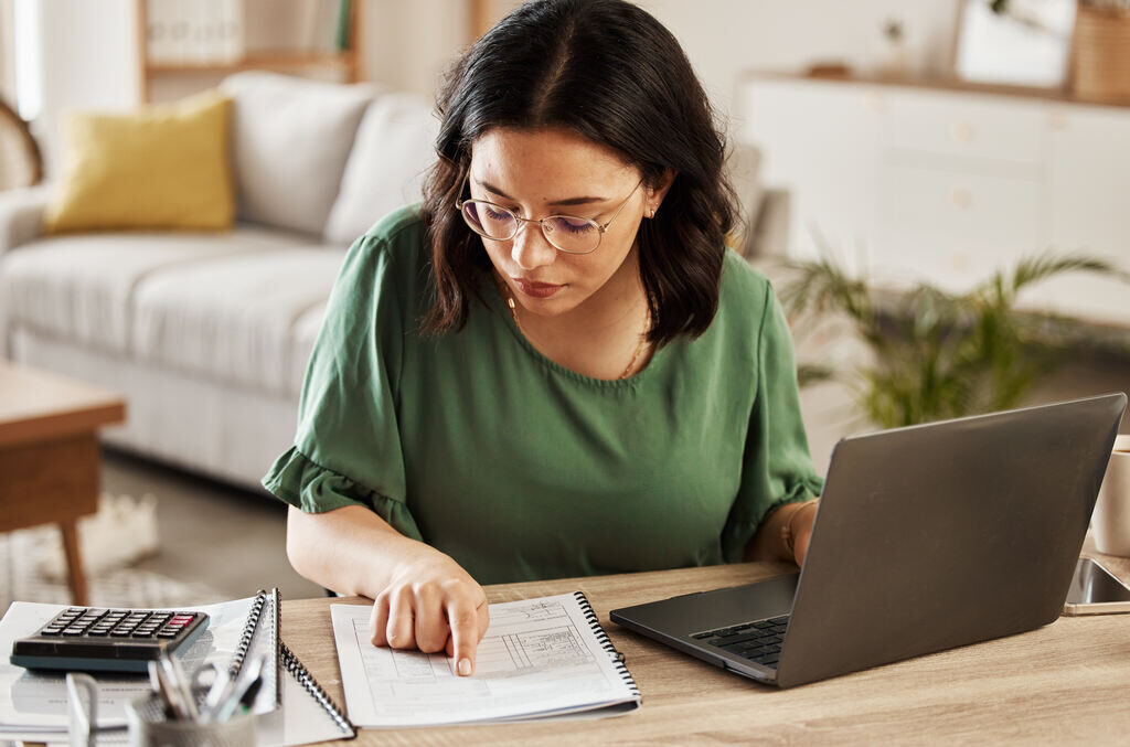 mulher com notebook preparando planejamento financeiro para 2025