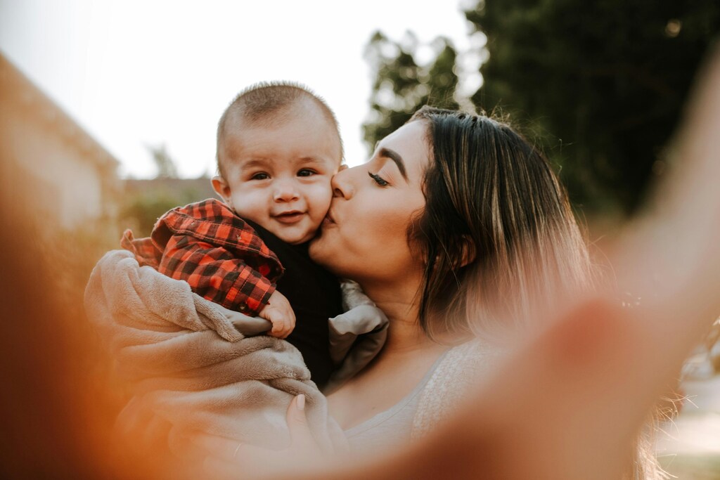 mãe beijando bebê representando quanto custa ter um filho