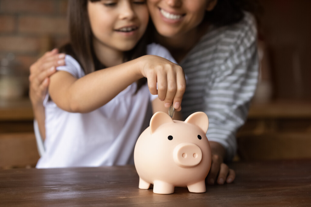 mãe e filha adicionando moeda em porquinho representando como economizar dinheiro ganhando pouco