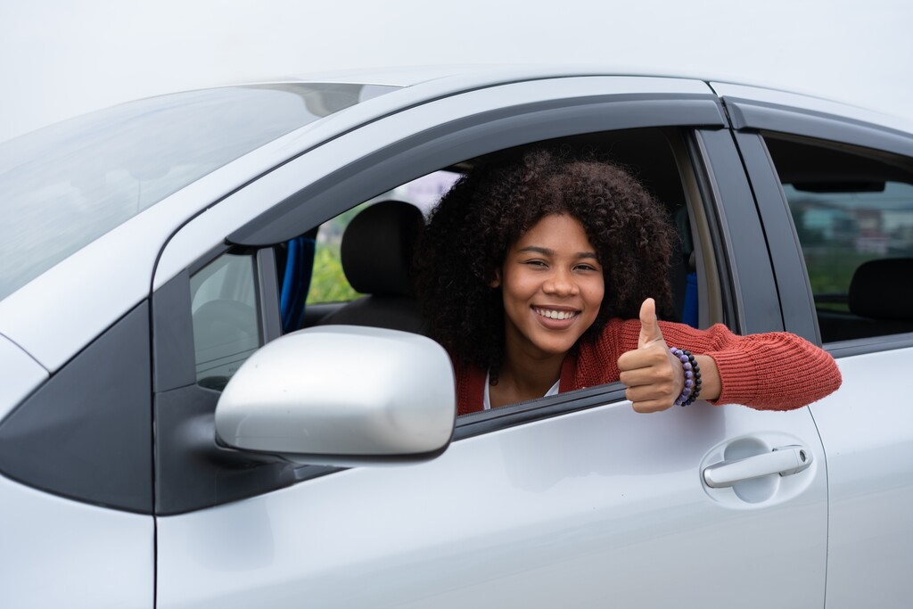 Mulher feliz no seu carro depois de entender como planejar a compra de um carro