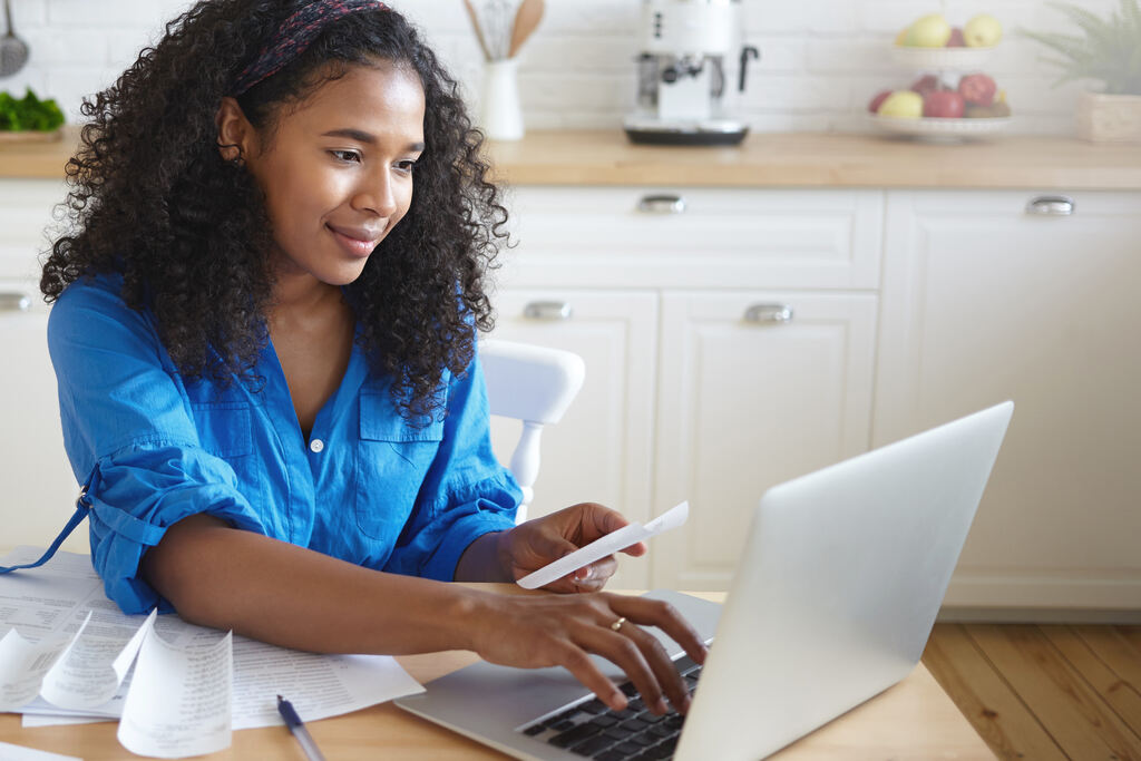 mulher pesquisando no notebook se vale a pena pagar dívida caducada